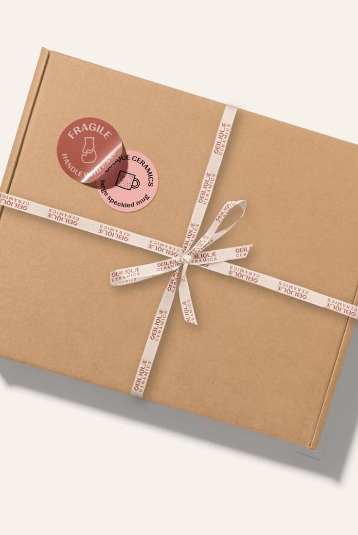 a wrapped gift box with a ribbon and stamp on it