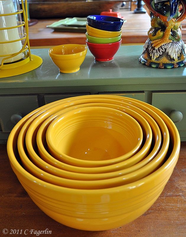 a stack of yellow bowls sitting on top of a table