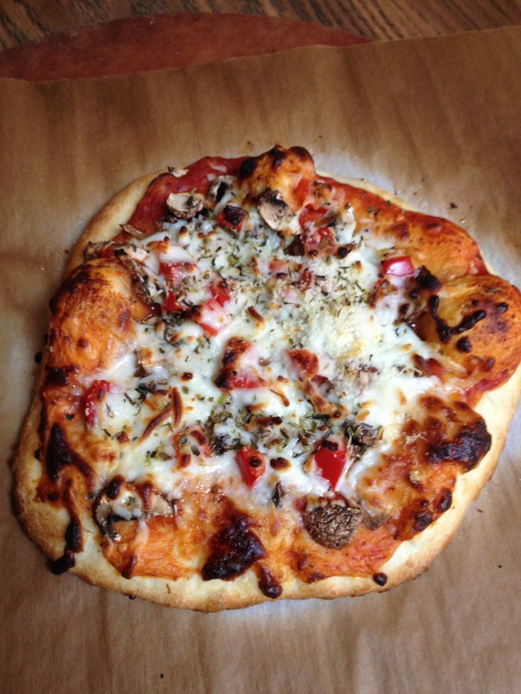 a pizza sitting on top of a piece of paper covered in cheese and toppings