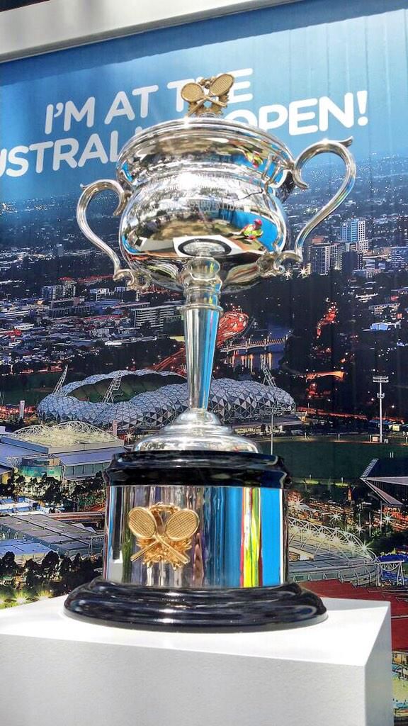 a silver trophy sitting on top of a white pedestal in front of a sign that says i'm at the australian open