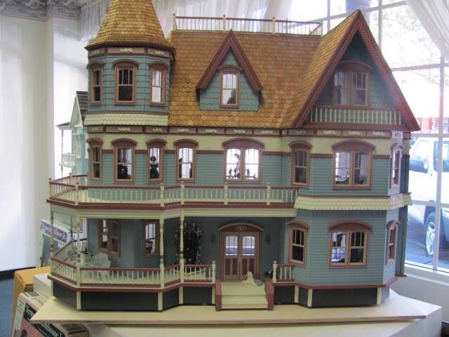 a doll house is on display in front of a window