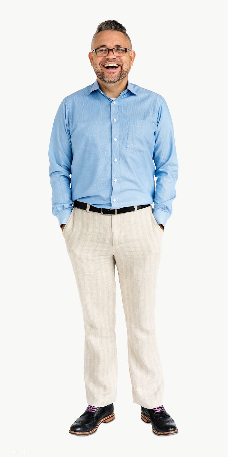 a man standing in front of a white background wearing glasses and a blue shirt with his hands in his pockets