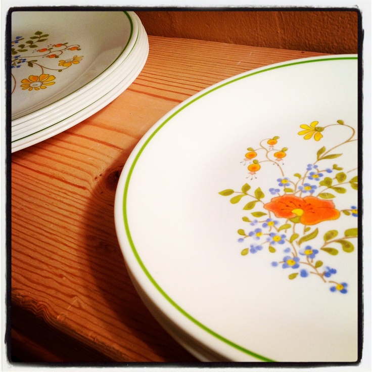 two plates with flowers painted on them sitting on a table next to another plate and bowl