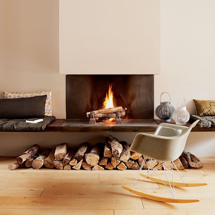 a living room with a fire in the fireplace next to a chair and other furniture