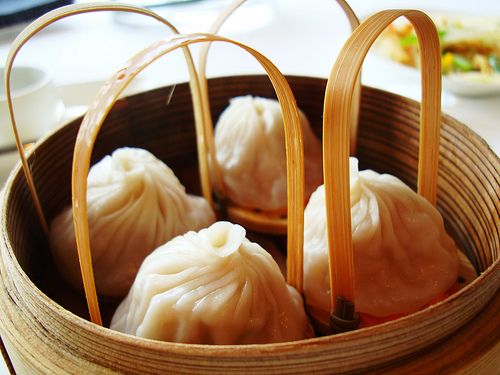 some dumplings in a bamboo basket on a table