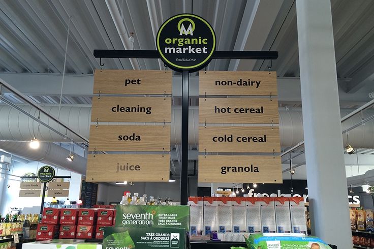 a store display with signs hanging from the ceiling and various products on shelves in front of them