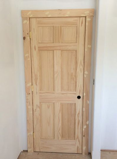 a wooden door in the corner of a room