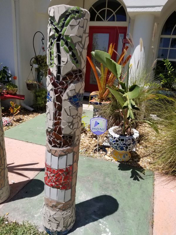 a tall decorative pole sitting in front of a house