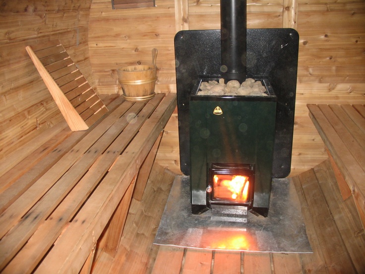 a wood burning stove sitting inside of a wooden room