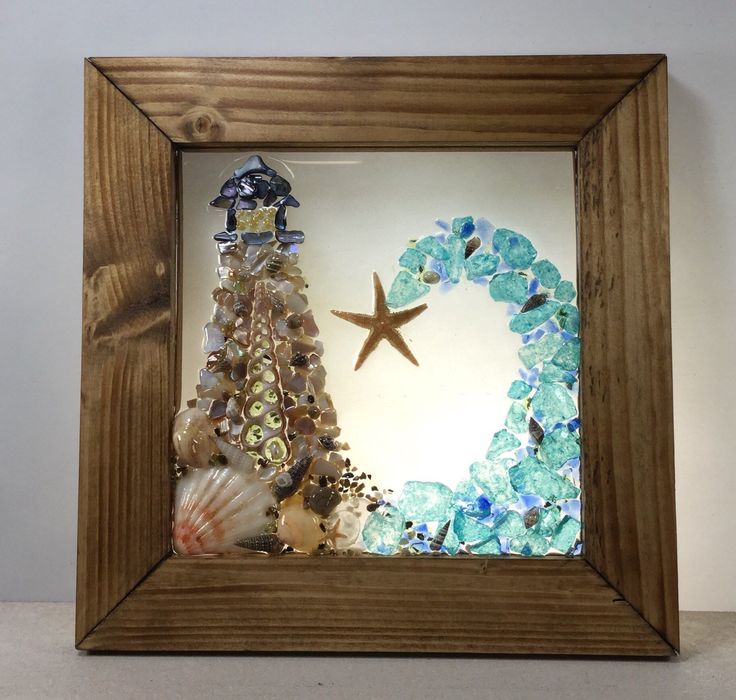 a wooden frame with sea glass and seashells in the shape of a christmas tree