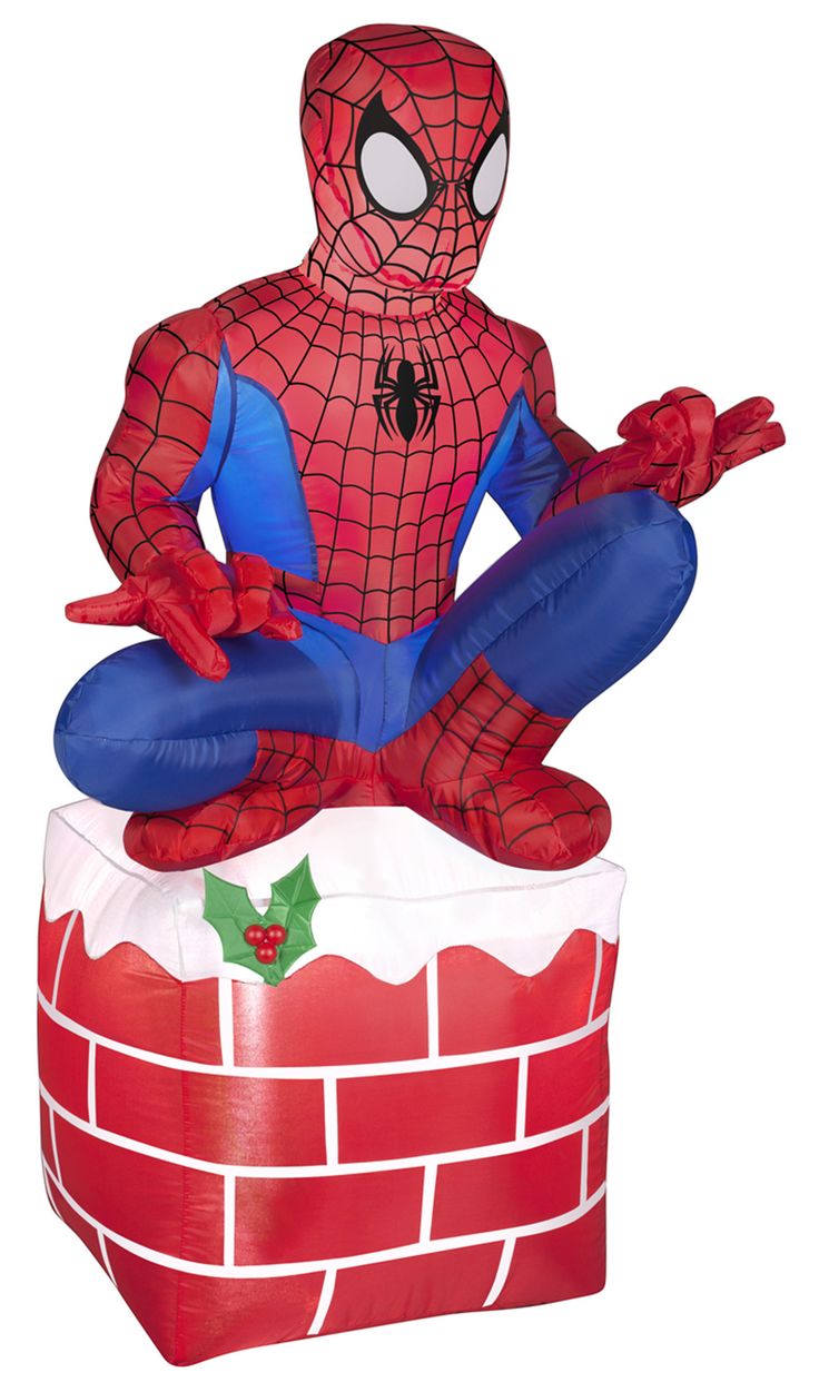 an inflatable spider man sitting on top of a brick wall with holly berries