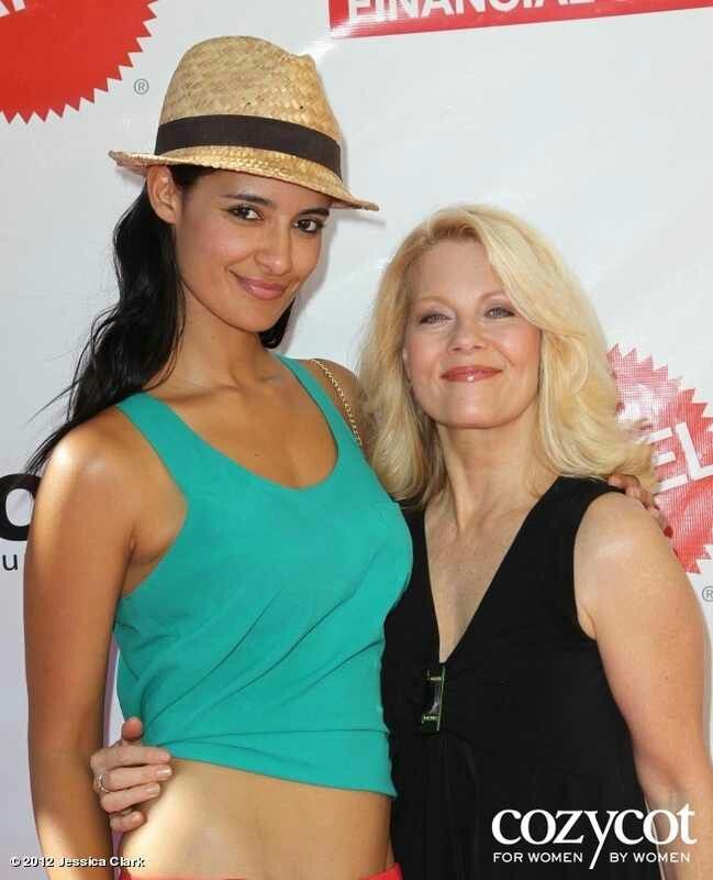 two women standing next to each other on a red carpet