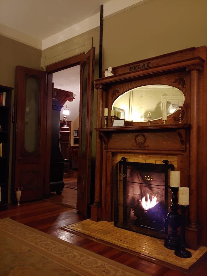 a living room with a fire place in the center and a mirror on the wall