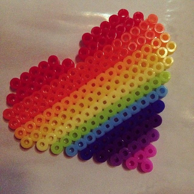 there is a rainbow colored object made out of plastic pegs on the table top