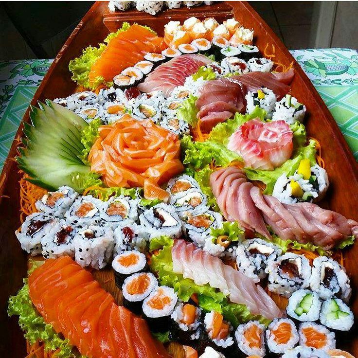 a wooden boat filled with lots of different types of sushi