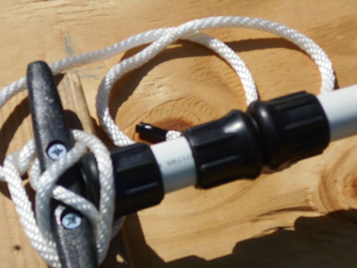 a close up of a bike handlebar on a wooden table with white and black cords