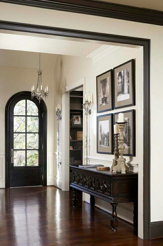 an ornate entry way with pictures on the wall and wooden flooring in front of it