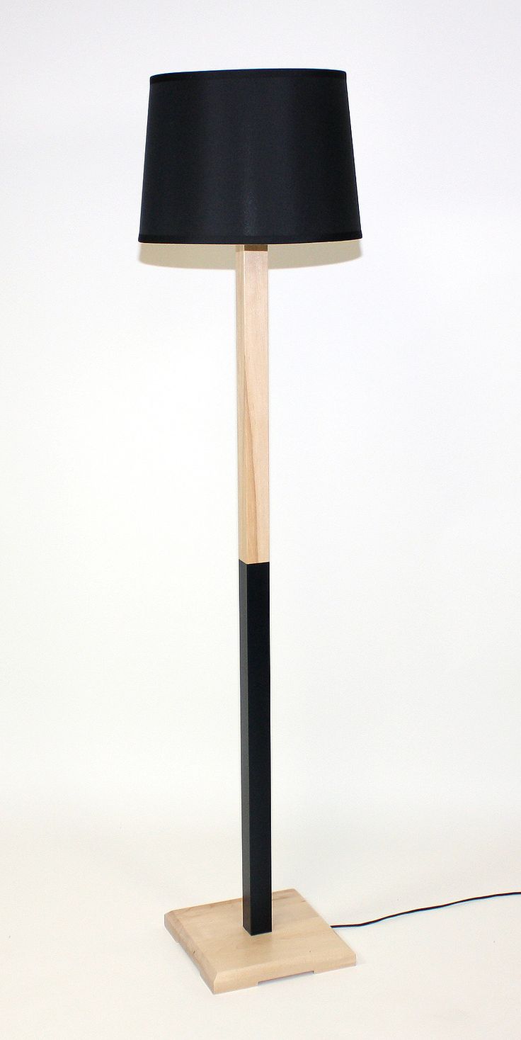 a lamp that is on top of a wooden stand with a black lampshade