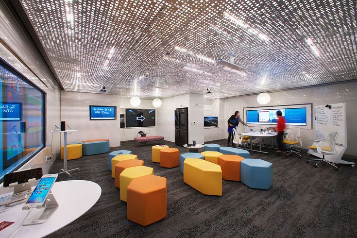 an office with chairs, desks and monitors on the walls that are covered in lights