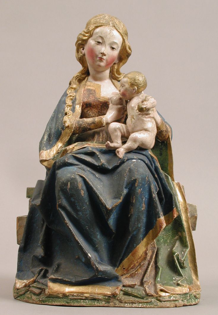 a statue of a woman holding a baby in her lap and sitting on a chair