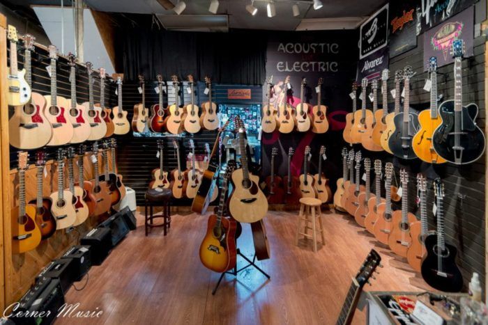 guitars are lined up on display in the music store's guitar room, which also includes acoustic instruments