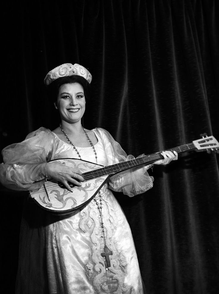 a woman in an ornate dress holding a guitar