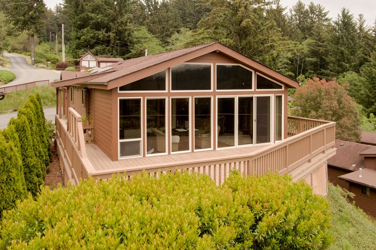 a house with lots of windows on the side of it and trees in the background