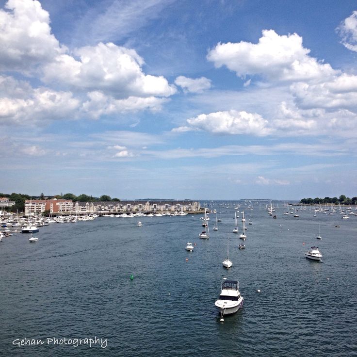 many small boats are in the water on a sunny day with blue sky and white clouds