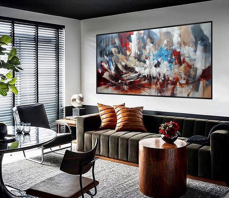 a living room filled with furniture and a large painting on the wall over a glass table