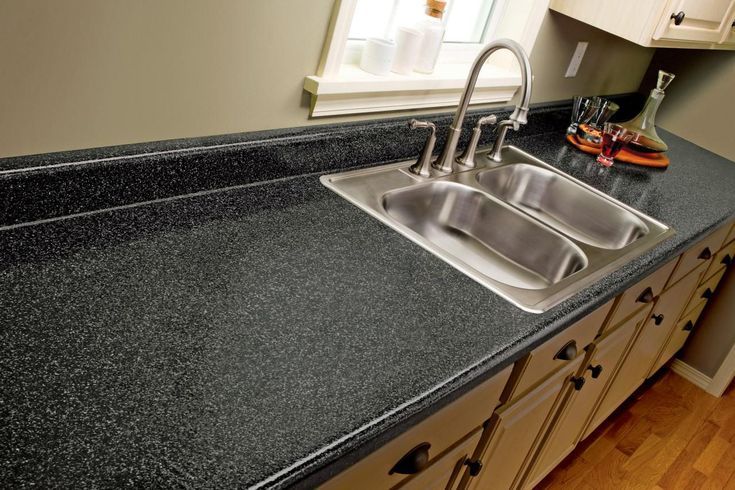 a kitchen with black counter tops and wooden floors