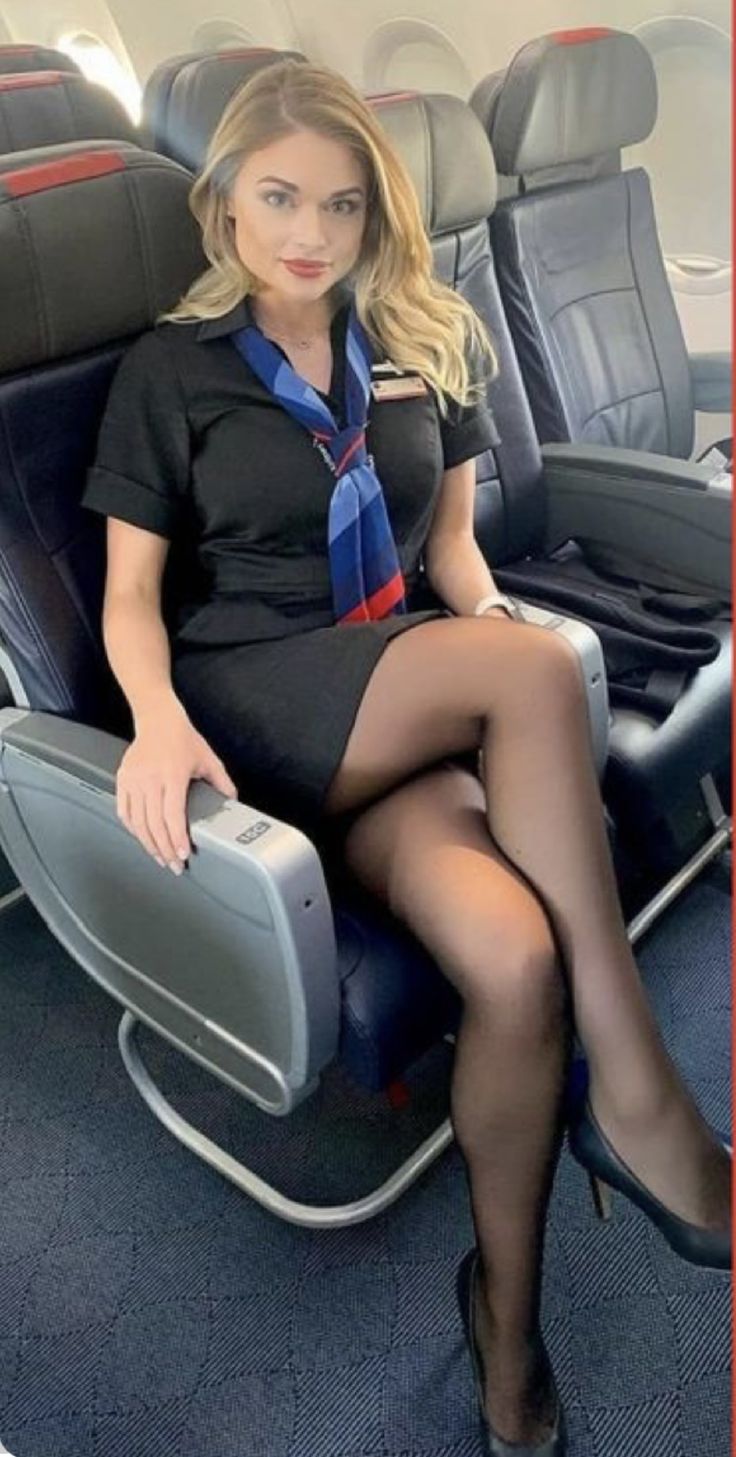 a woman sitting in an airplane seat with her legs crossed