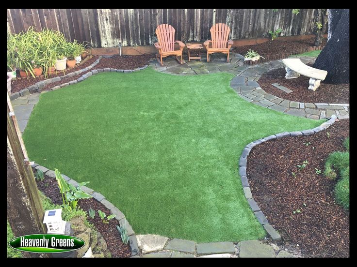 a backyard with artificial grass and lawn furniture