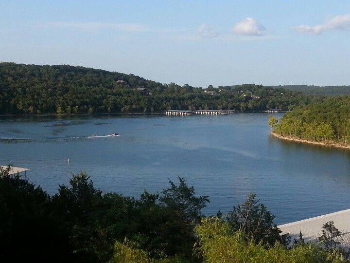 a body of water surrounded by trees and hills