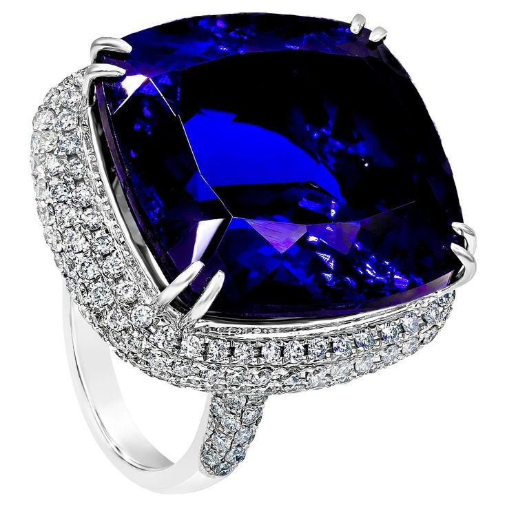 A splendid cocktail ring showcasing an amazing color-rich cushion cut tanzanite weighing 44.04 carats total. Elegantly set in a double claw prongs setting, with micro-pave diamonds set around the center stone. Diamonds weigh 2.43 carats total. Made in 18K White Gold. Size 6.75 US resizable upon request. Style available in different price ranges. prices are based on your selection. Please contact us for more information. Elegant Tanzanite Diamond Cut Ring, Luxury Cushion Cut Sapphire Ring, Square Cut Sapphire Ring With Diamonds For Formal Occasions, Luxury Tanzanite Ring With Diamond Cut, Formal Sapphire Ring With Brilliant And Cushion Cut, Formal Sapphire Ring With Cushion Brilliant Cut, Formal Sapphire Ring With Cushion Cut And Prong Setting, Luxury Cushion Cut Sapphire Diamond Ring, Luxury Cushion Cut Sapphire Ring With Prong Setting