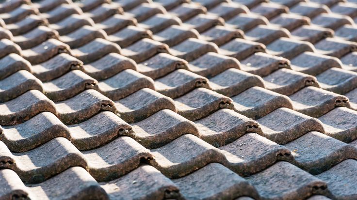 a close up view of an old roof made out of cement tiles with small holes in the middle