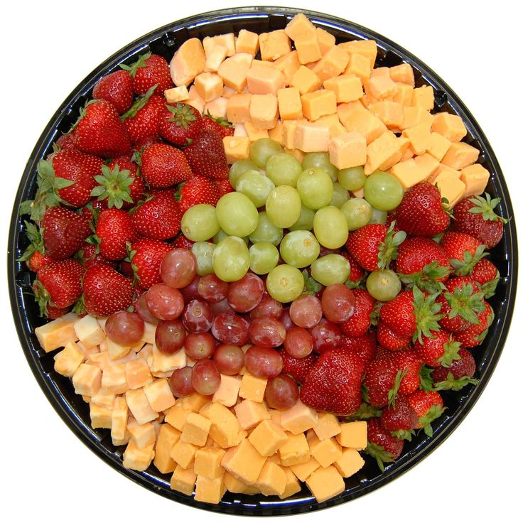 a platter of cheese, grapes and strawberries on a black plate with white background