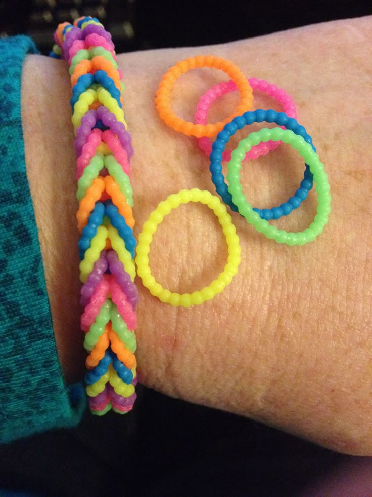 a woman's arm with colorful bracelets on it