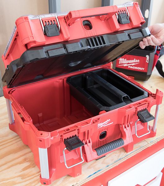 a red tool box filled with tools on top of a wooden table