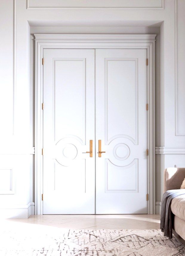 a white room with two doors and a rug on the floor