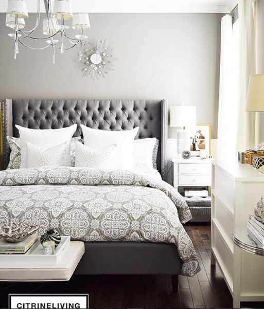 a bedroom with a bed, nightstands and chandelier hanging from the ceiling