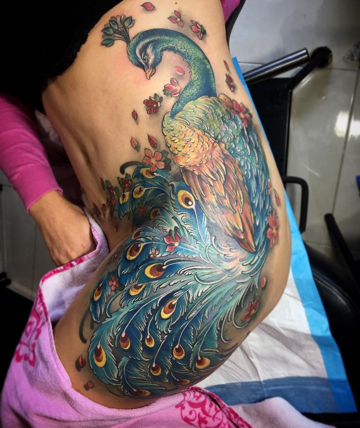 a woman with a peacock tattoo on her stomach