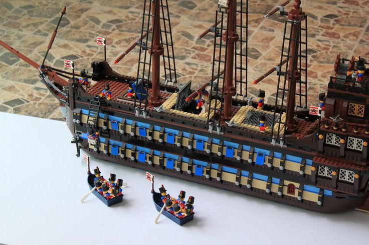 a lego model of a pirate ship with three small figures on the front and side