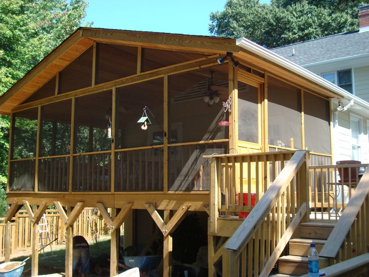 a wooden deck with stairs leading up to the upper floor and second story above it