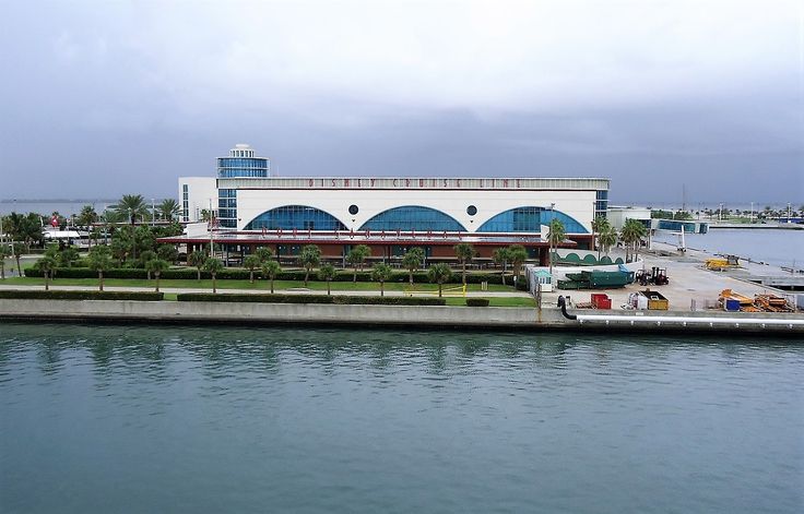 a large building sitting on the side of a body of water next to a pier