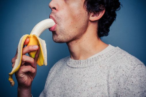 a man is taking a bite out of a banana