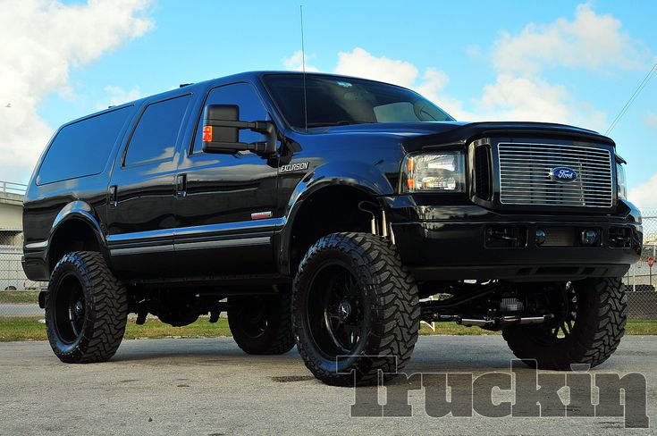 a large black truck parked on top of a parking lot