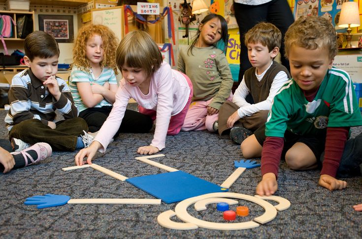 a group of children sitting on the floor playing with toys