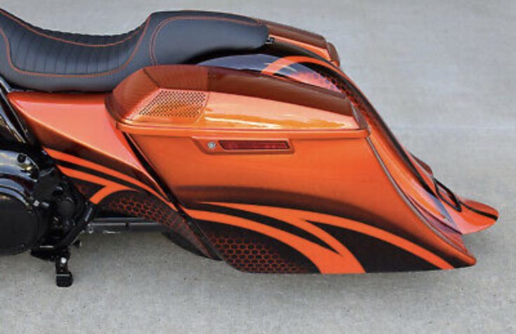 an orange and black motorcycle parked on the street