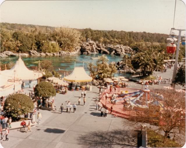 an aerial view of a carnival park with people walking around and riding on the rides