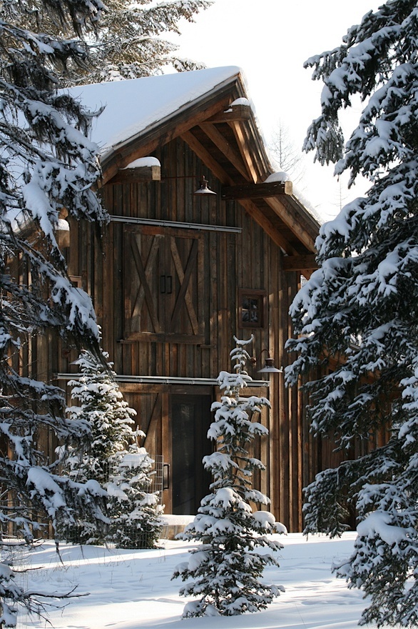 a wooden building surrounded by snow covered trees